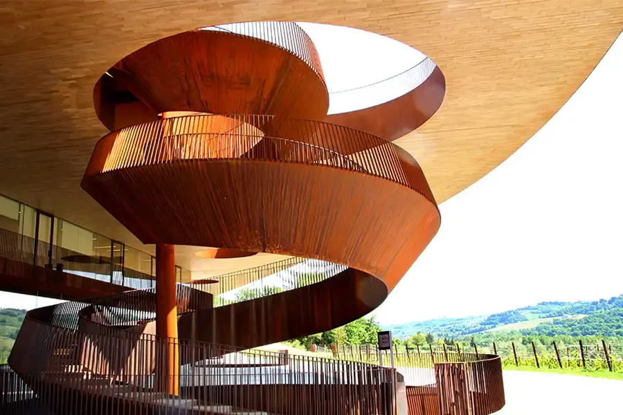 Modern spiral staircase at the Antinori nel Chianti Classico winery, made of weathered steel, overlooking the vineyards of Tuscany. 