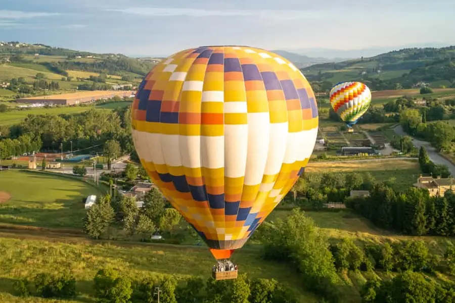 Hot air balloons flying over the Tuscan countryside, a unique experience during the Palio di Siena festivities.
